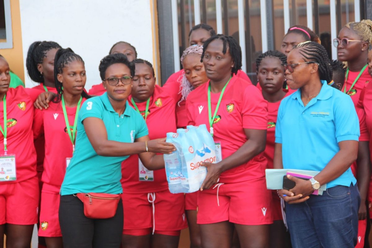 Remise de packs d’eau aux joueuses de la sélection nationale féminine de rugby, en tenue rouge