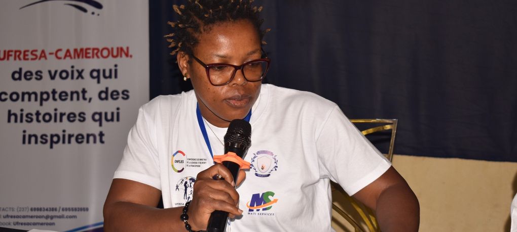 Une intervenante au micro devant le kakémono d’UFRESA Cameroun