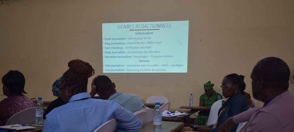 Participantes en séance de travail devant une présentation sur les genres rédactionnels